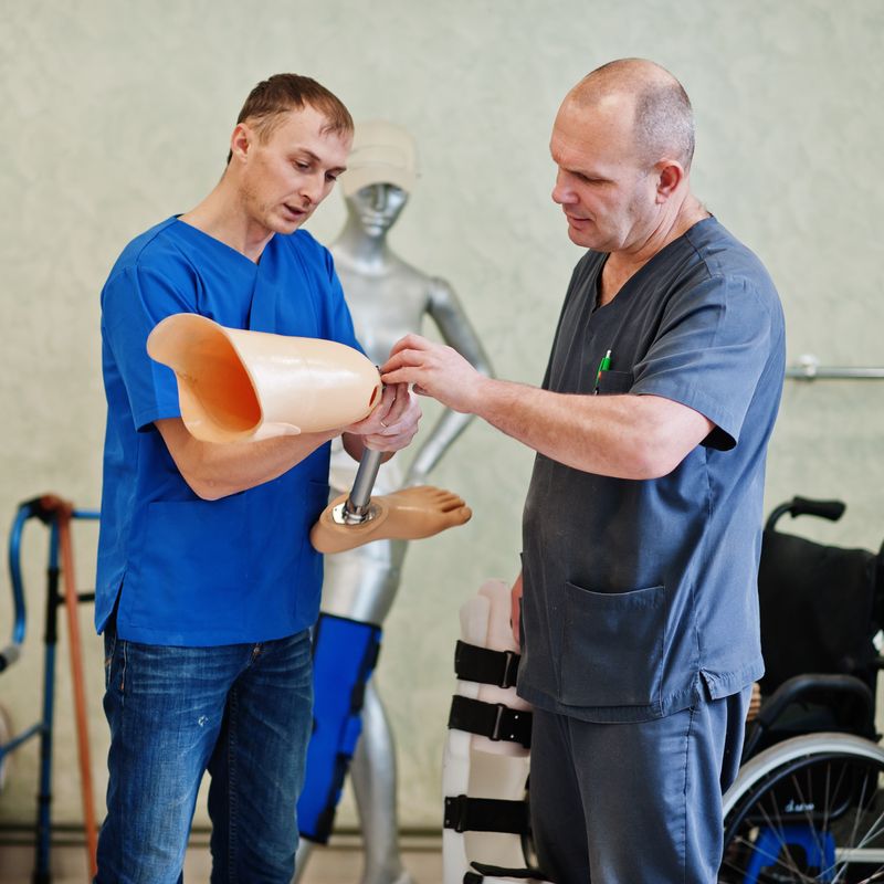 two-prosthetist-man-workers-with-prosthetic-leg-working-laboratory